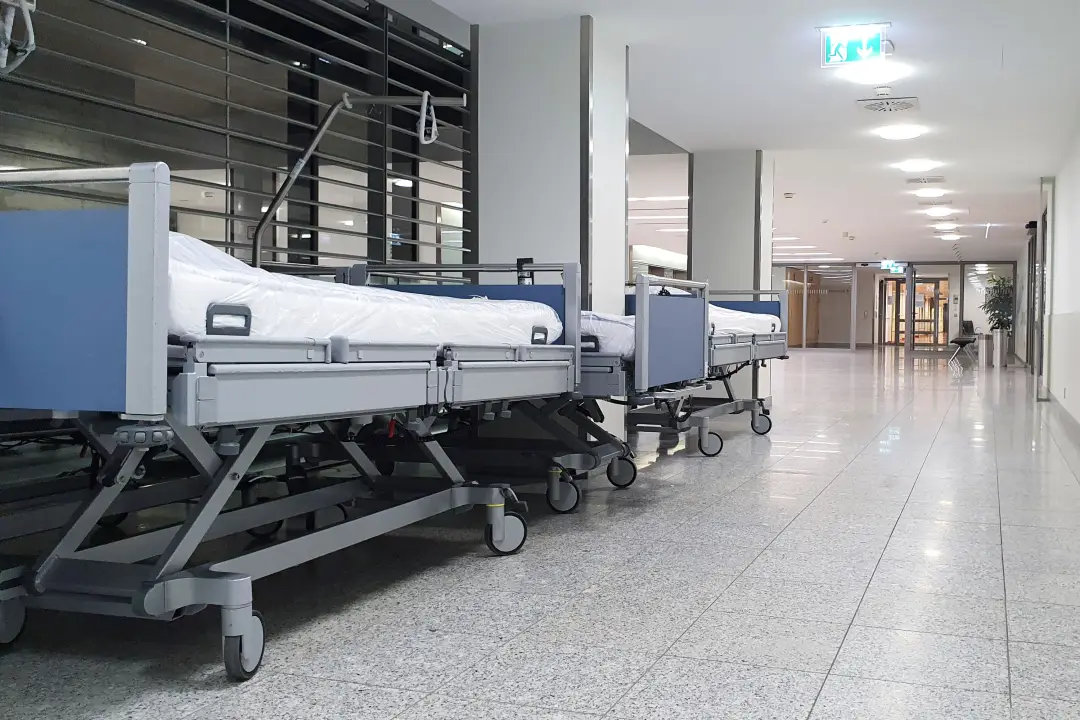 Modern bir hastanede beyaz çarşaflarla hazırlanmış hasta yatakları